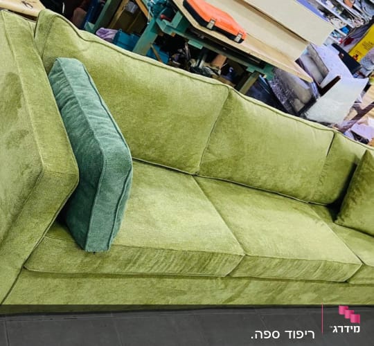 ספה ירוקה עם כריות מרופדות בחנות רהיטים